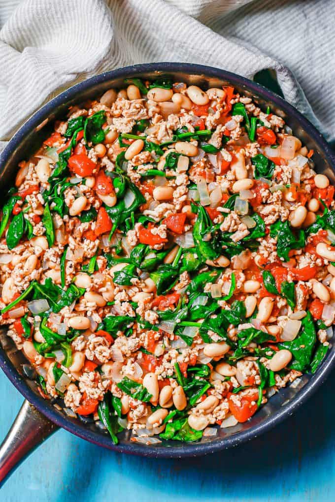 A ground chicken skillet with cannellini beans, tomatoes and spinach.