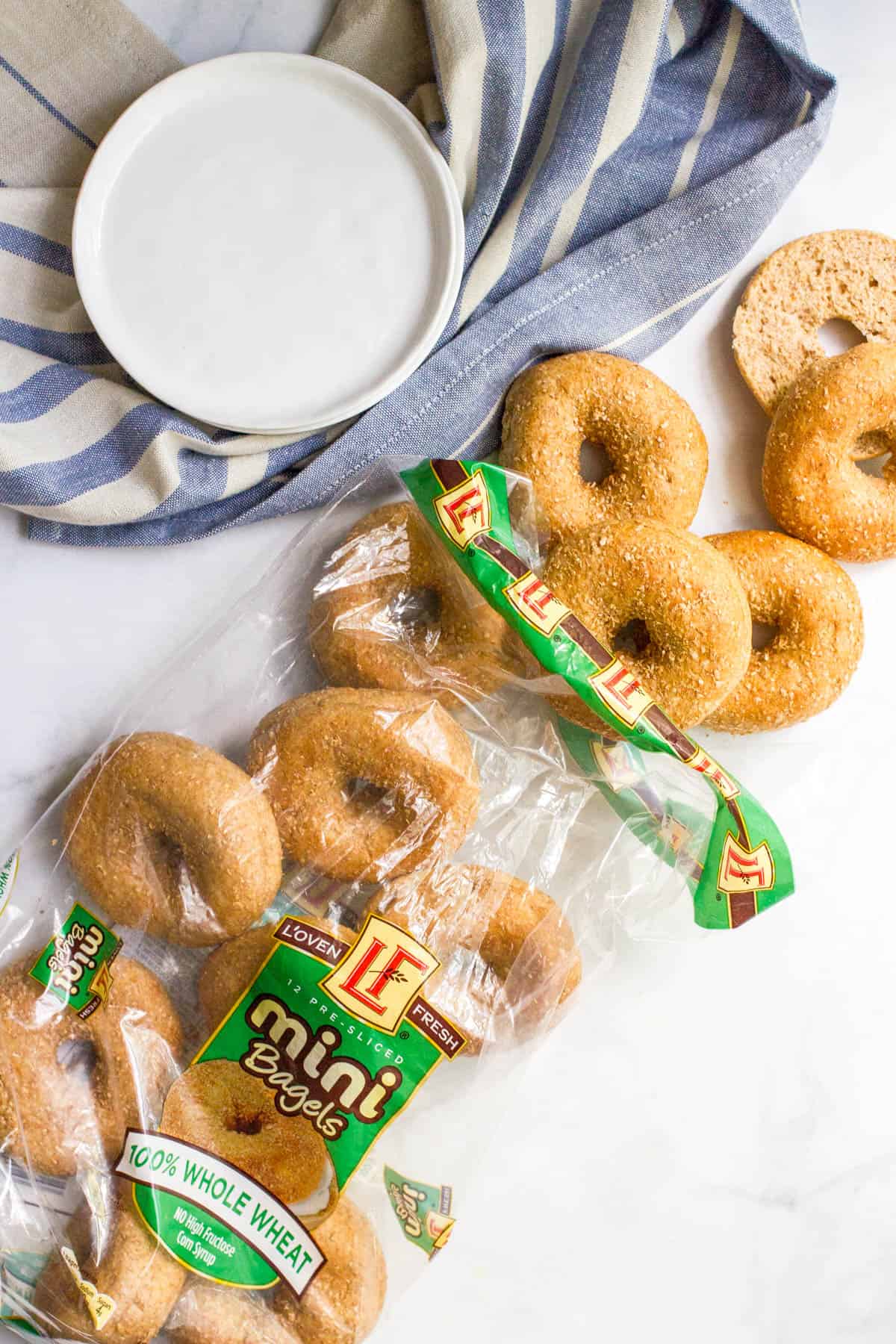 A bag of mini whole wheat bagels being spilled onto a counter.