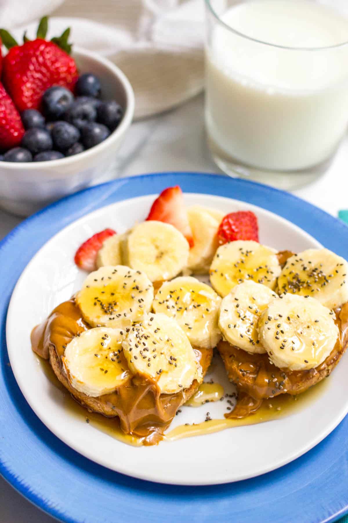 A bagel topped with peanut butter, sliced bananas, chia seeds and a drizzle of honey.