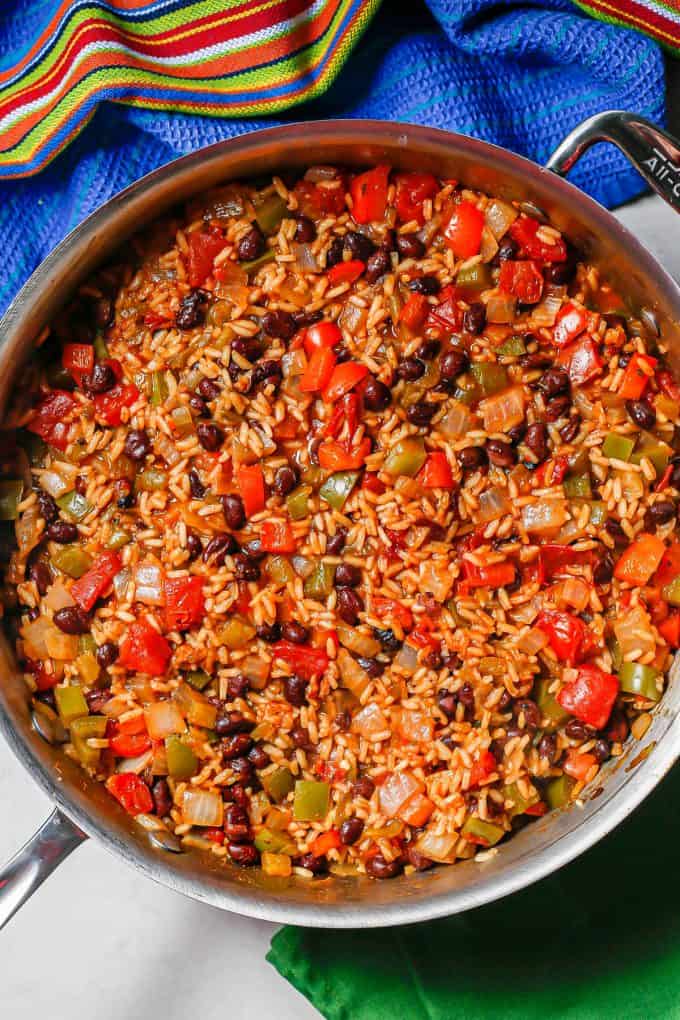 A mixture of cooked rice with black beans, tomatoes, peppers and onions.