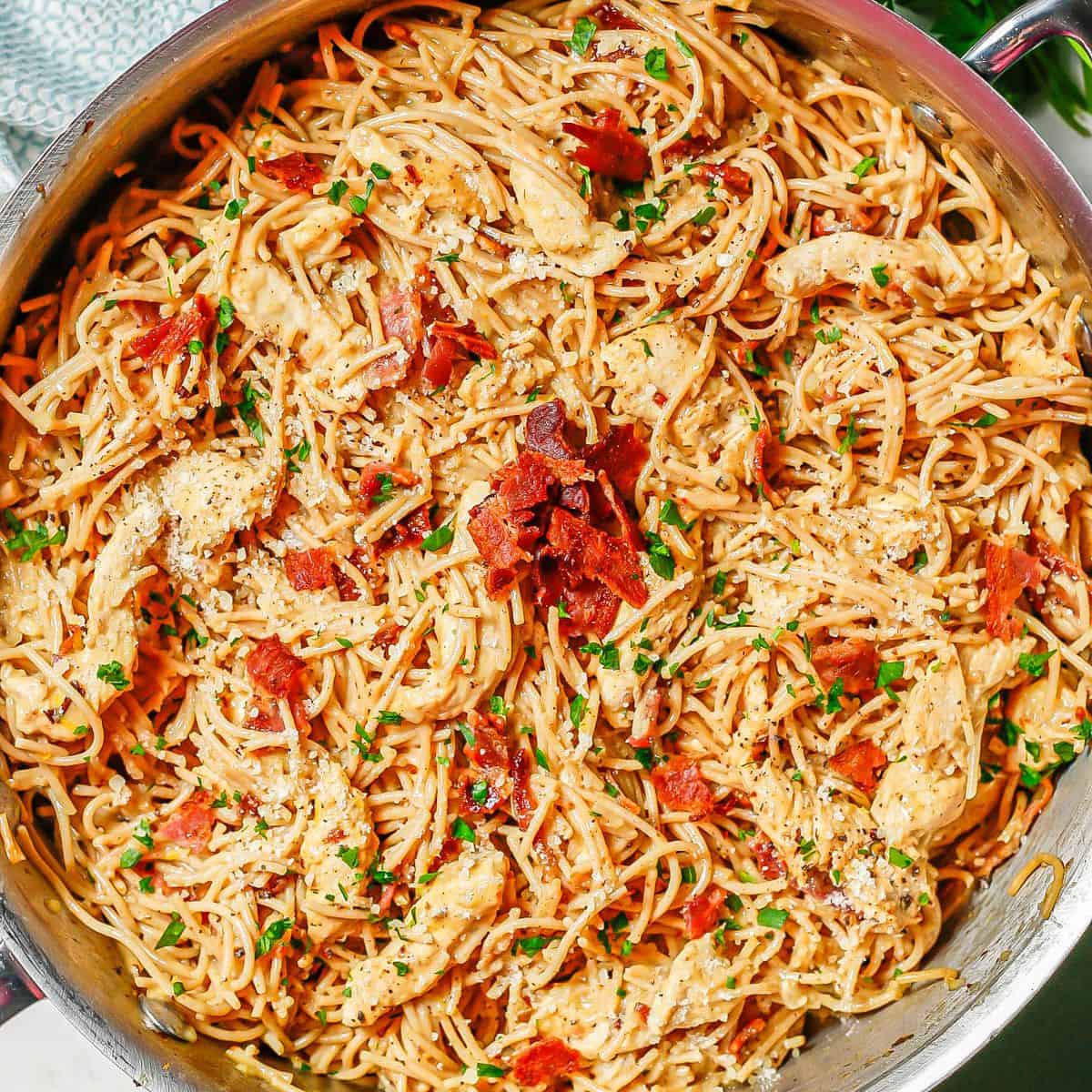 Close up of a skillet of cooked chicken carbonara before being served.