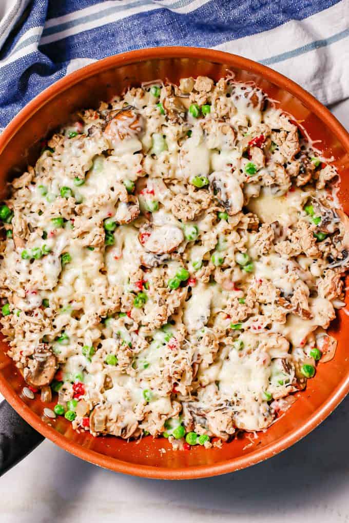A cheesy ground chicken skillet with mushrooms, peas and pimientos.