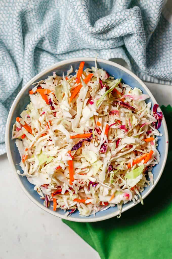 Coleslaw in a blue and white bowl.