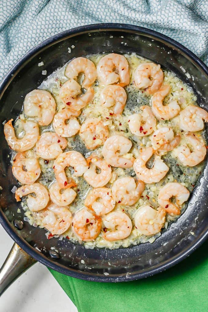 Cooked shrimp in a butter sauce in a large skillet.