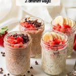 Strawberry overnight oats made 2 different ways and served in small glass jars on a white platter with spoons to the side and a text overlay on the photo.