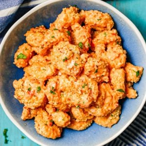 Close up of bang bang shrimp in a blue and white bowl.