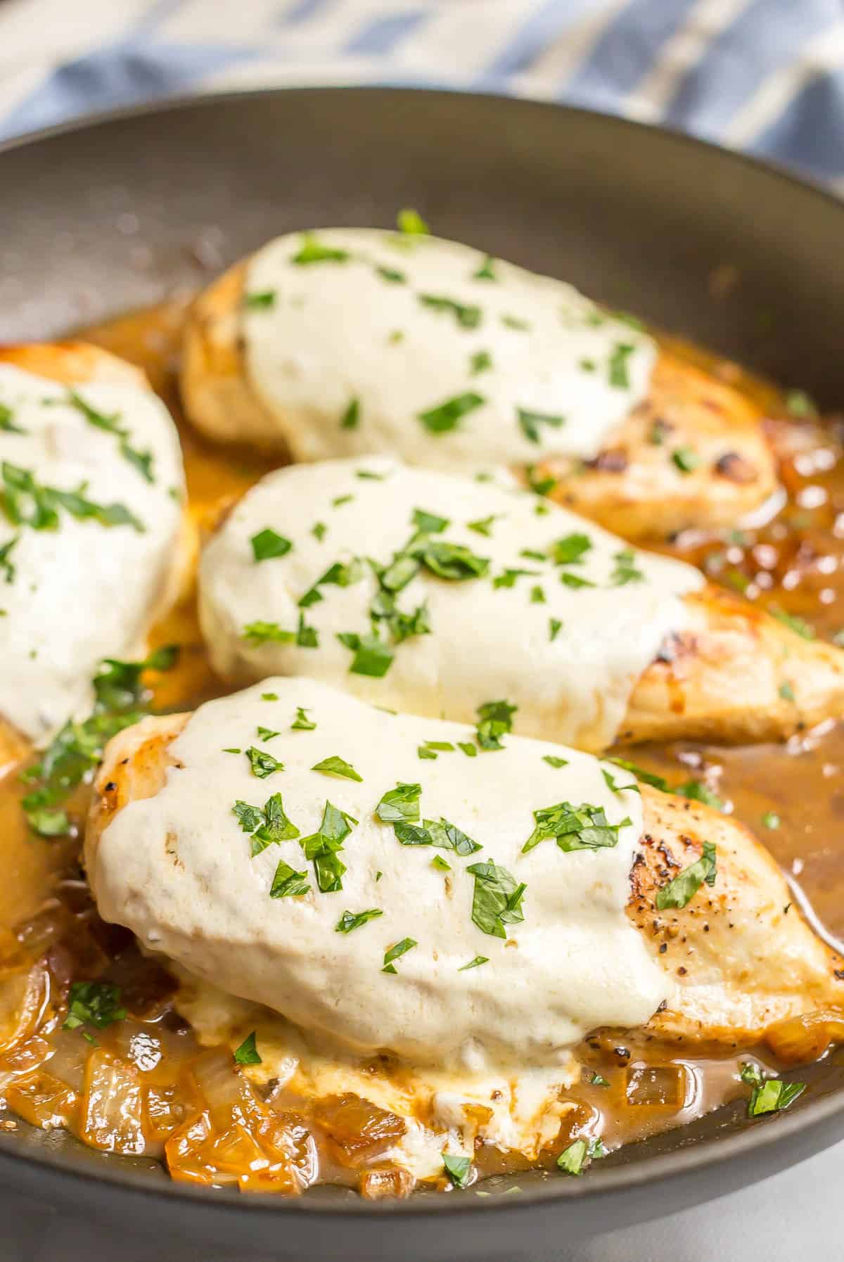 Close up of a mozzarella baked chicken breast in a skillet.