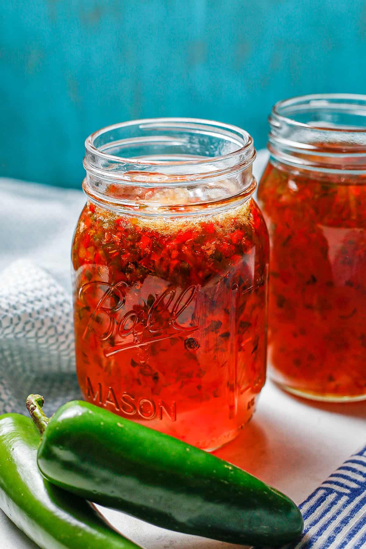 Jalapeno pepper jelly in a glass jar before it's cooled and set up.