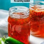 Homemade pepper jelly in a large glass jar with a couple of jalapeños in front and a text overlay on the photo.