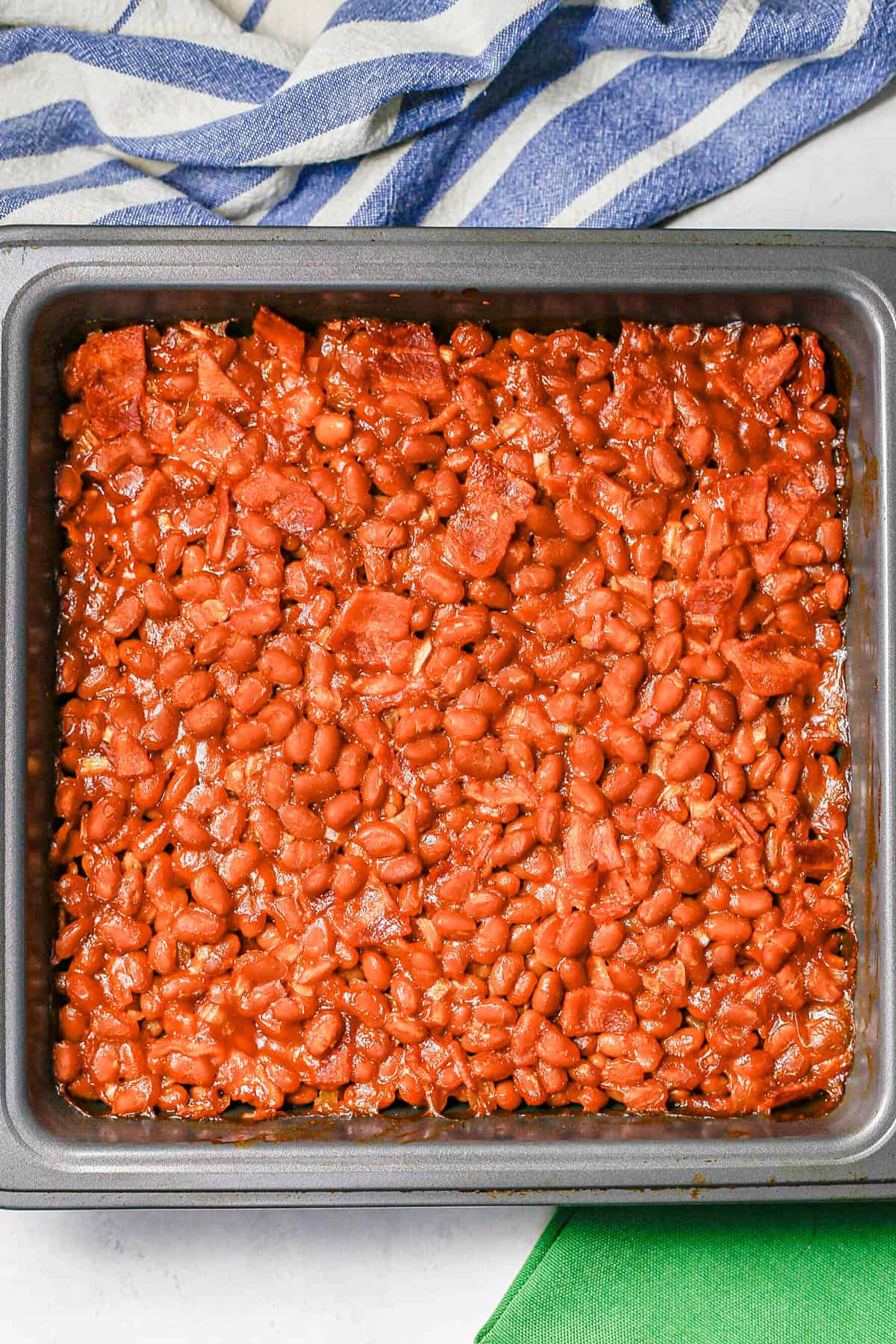 Baked beans with bacon in a square nonstick pan after cooking.