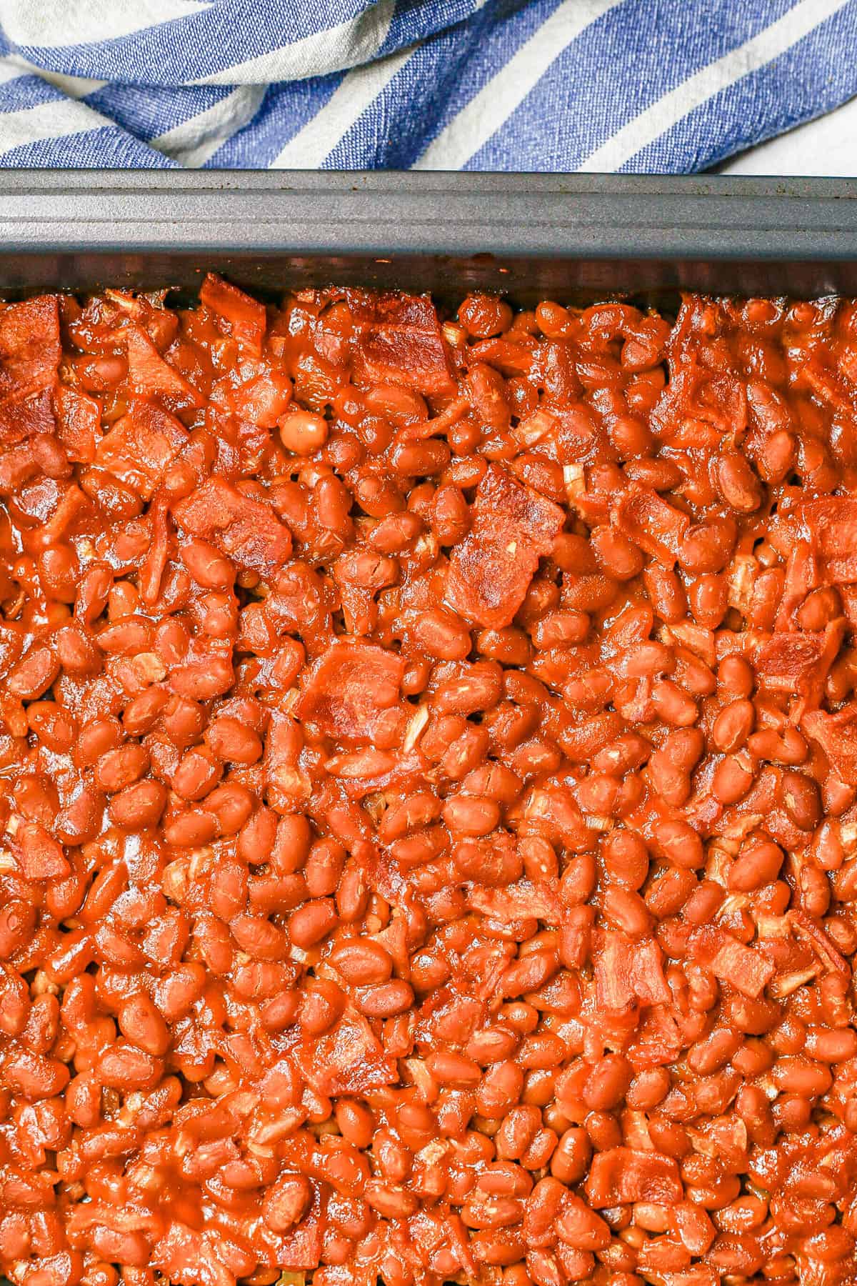 Close up of a pan of baked beans with bacon.