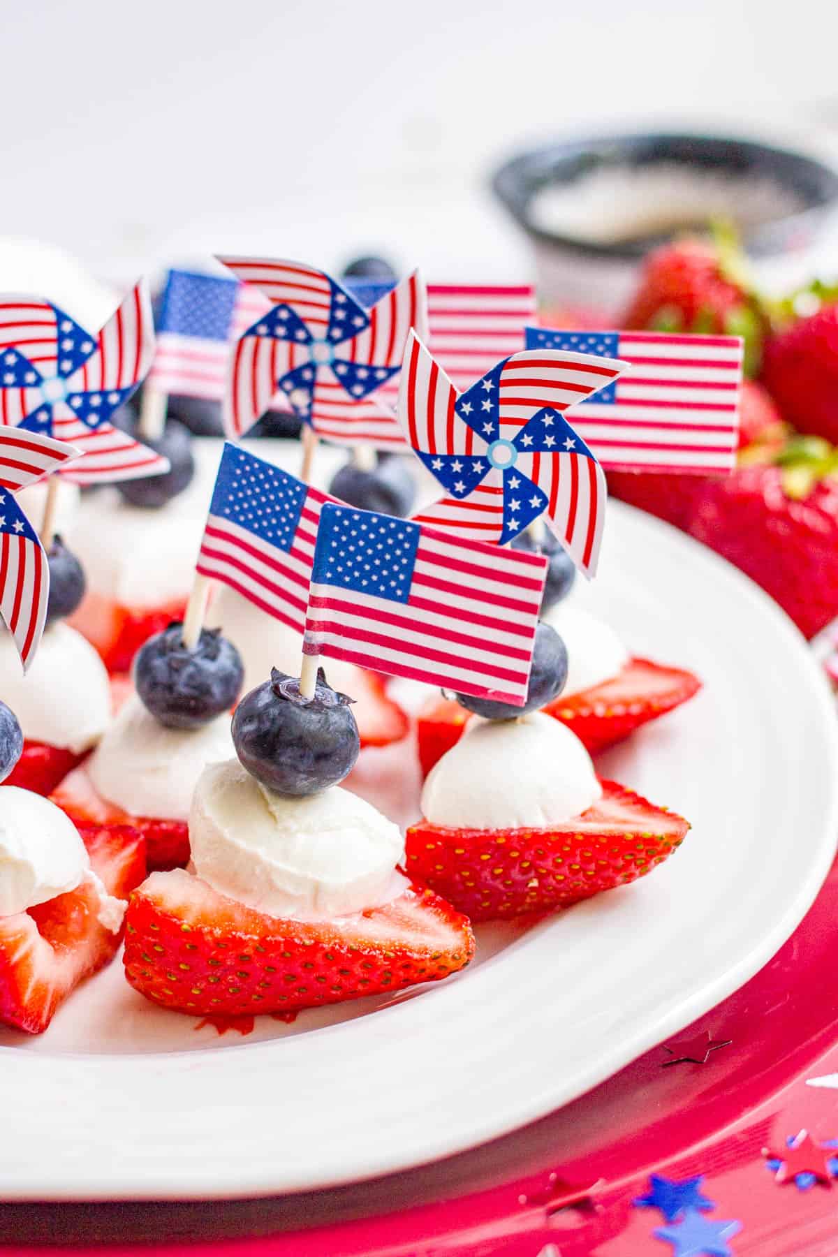 Red white and blue fruit and mozzarella stacks held together with small paper US flags.