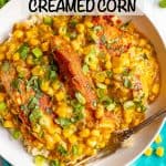 A low white bowl with seared skillet chicken with creamed corn, topped with cilantro and green onions and a fork resting in the bowl and a text overlay on the photo.