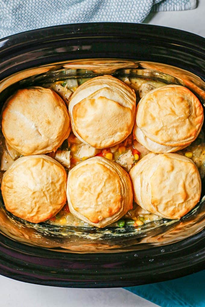 Biscuits on top of chicken pot pie in a crock pot.