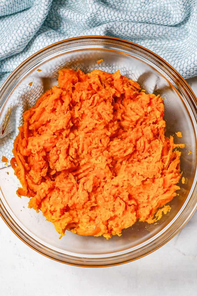 Mashed sweet potatoes in a large glass bowl.