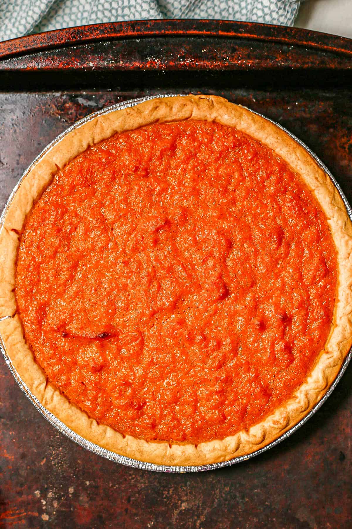 Sweet potato pie on a baking sheet after baking in the oven.