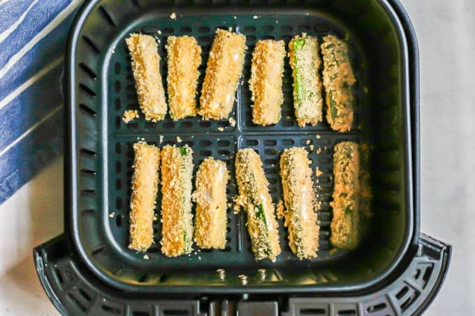 Breaded zucchini lined up in an Air Fryer before being cooked.