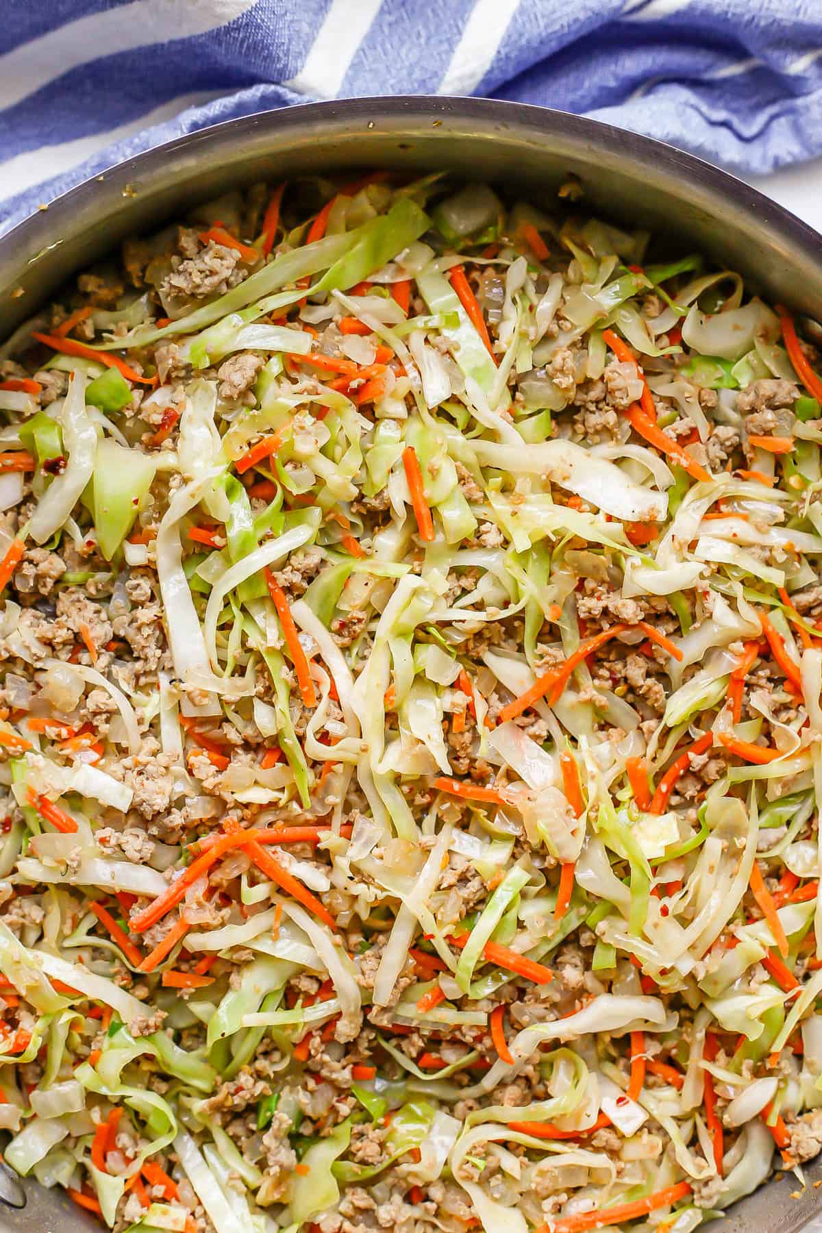 Close up of a large deep skillet with a ground turkey and cabbage mixture.