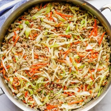Close up of an egg roll filling mixture with ground turkey, cabbage and carrots in a large deep skillet.