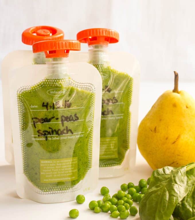 A trio of pear peas and spinach squeezes in clear pouches with orange lids.