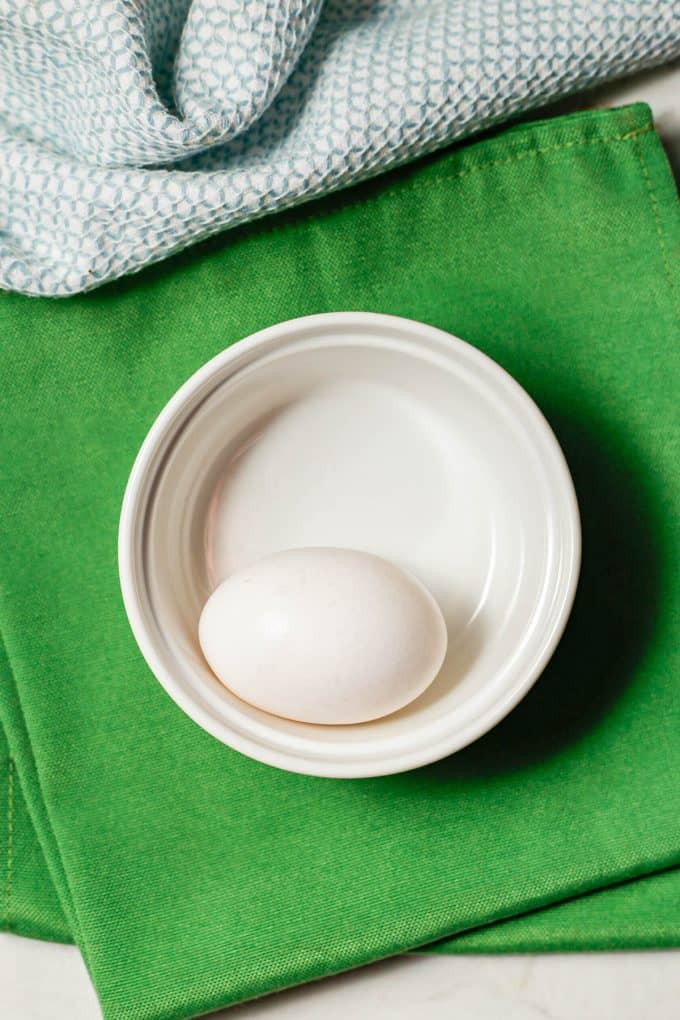 One large white egg in a small ramekin dish.