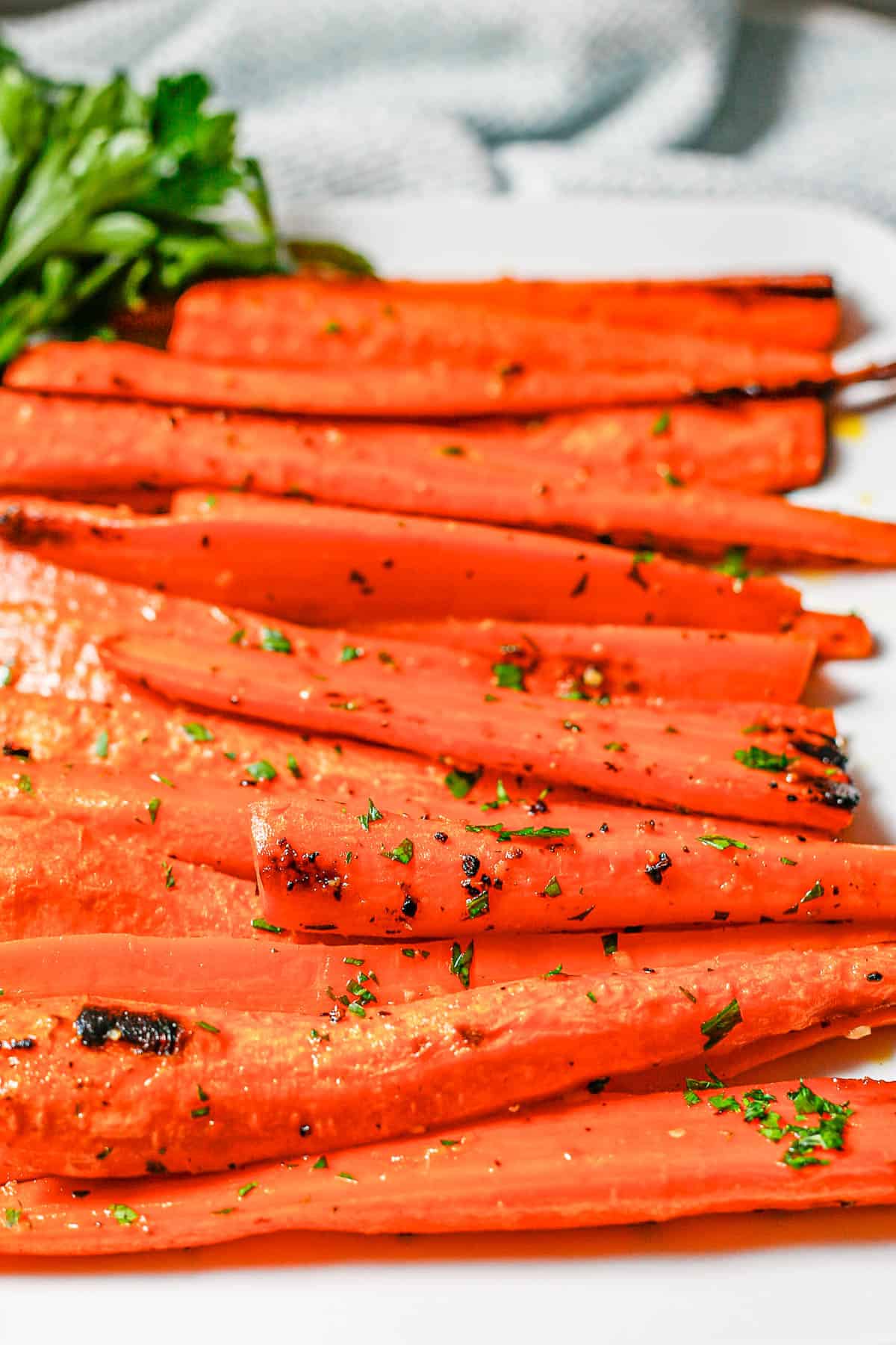 Close up of roasted carrots served on a white platter.