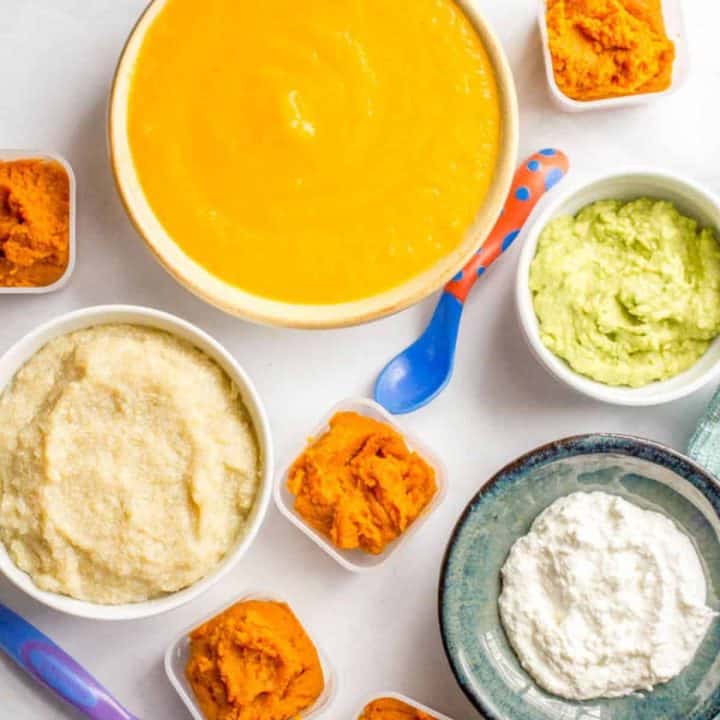 A grouping of different homemade baby food purees in different containers.