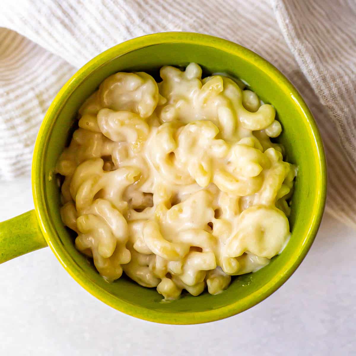 Close up of mac and cheese served in a green mug.