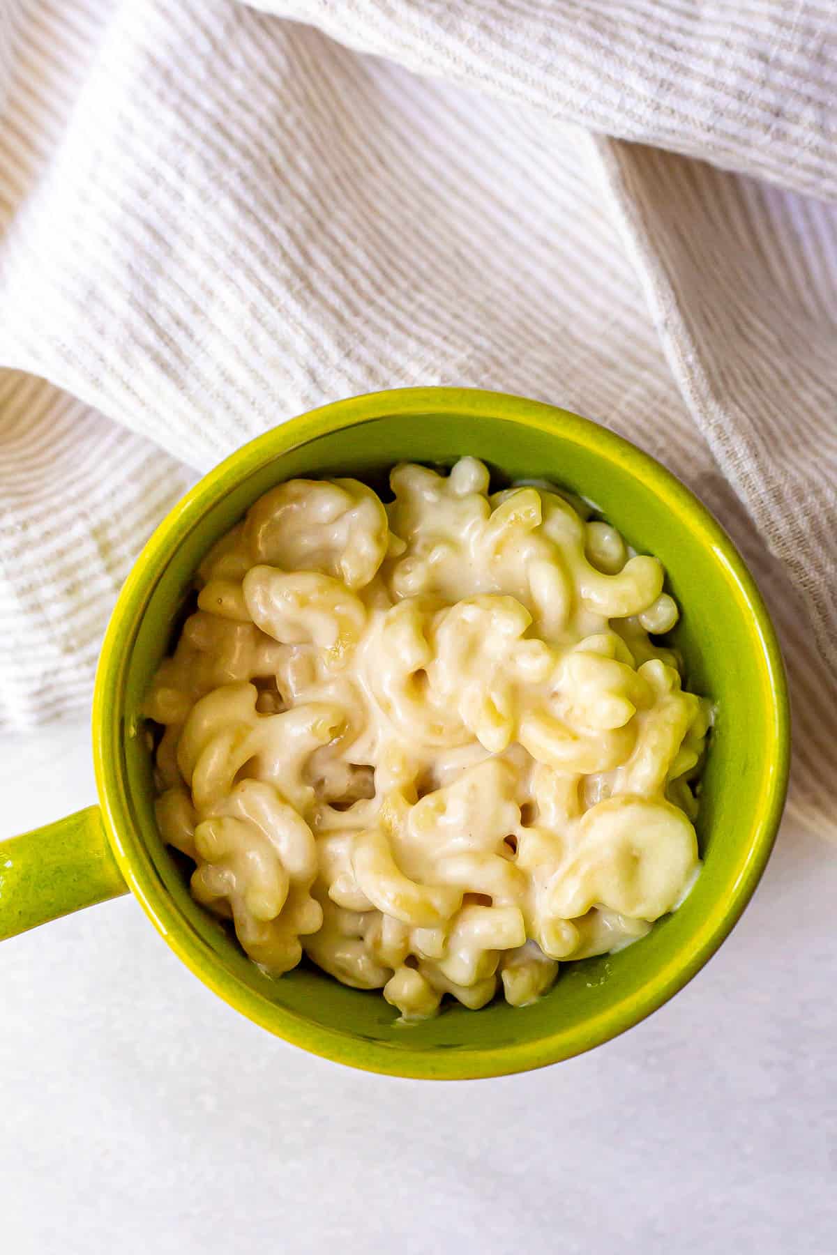 Mac and cheese served in a green mug.