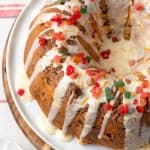 A Christmas coffee cake with an orange glaze drizzled over top and red and green gummy candies sprinkled on top and a text overlay on the photo.