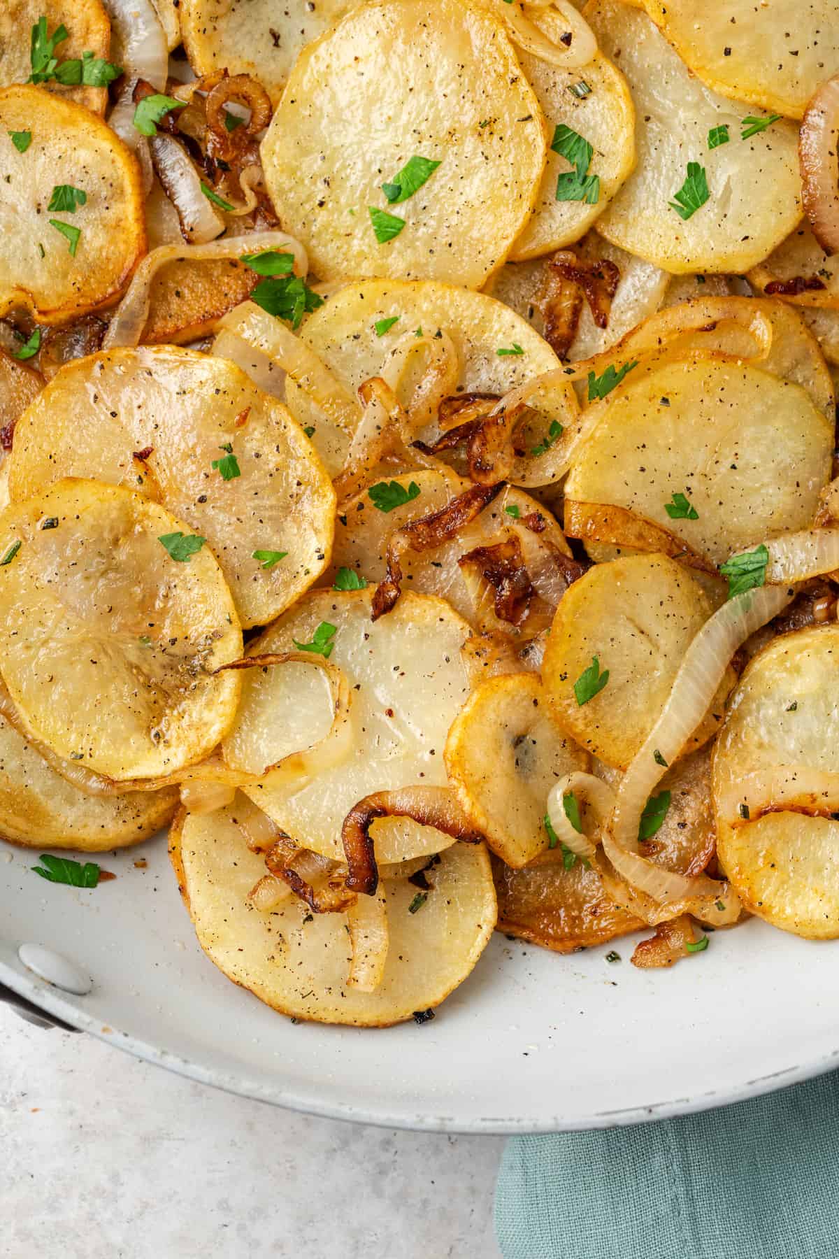 Close up of cooked potatoes Lyonnaise in a skillet.