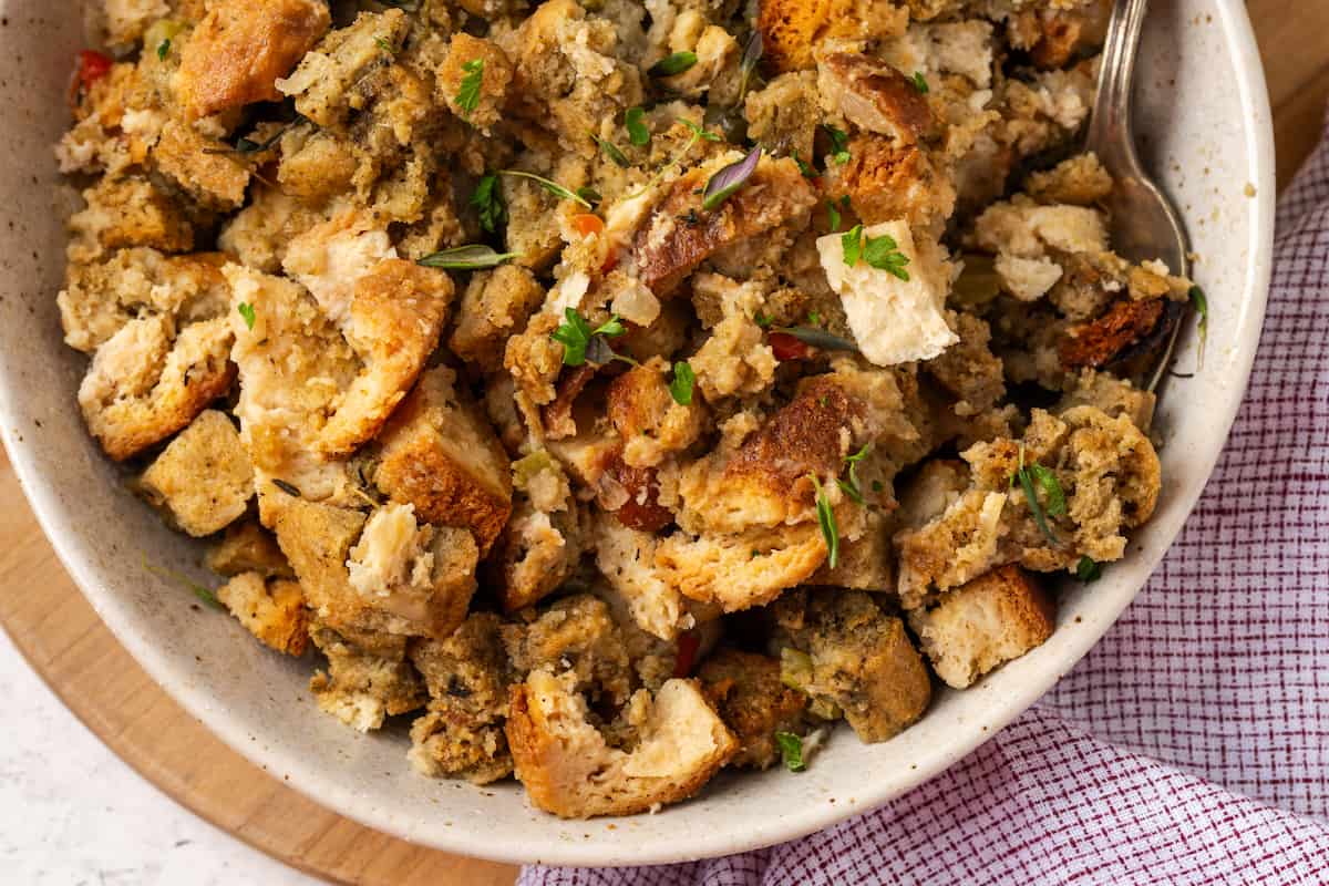 A spoon resting in a bowl of Thanksgiving dressing.