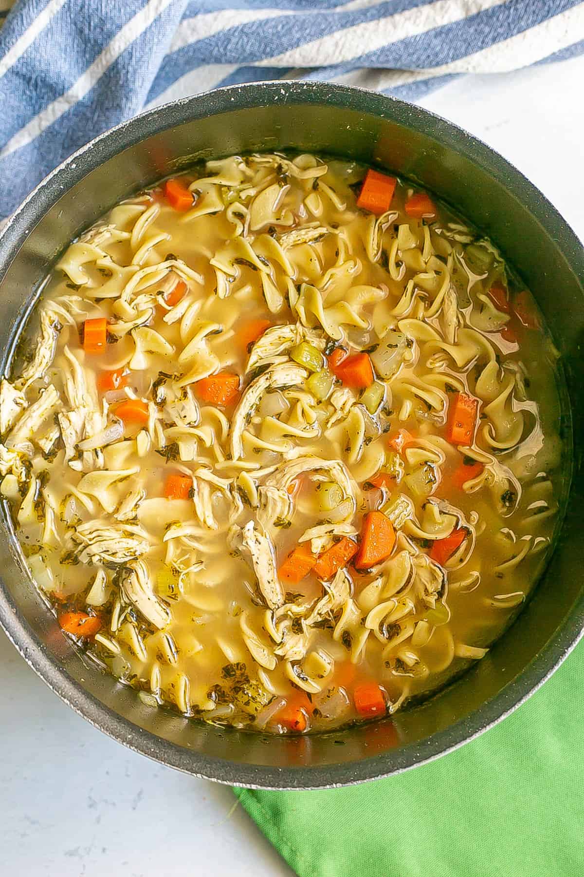 A large dark pot of easy homemade chicken noodle soup.