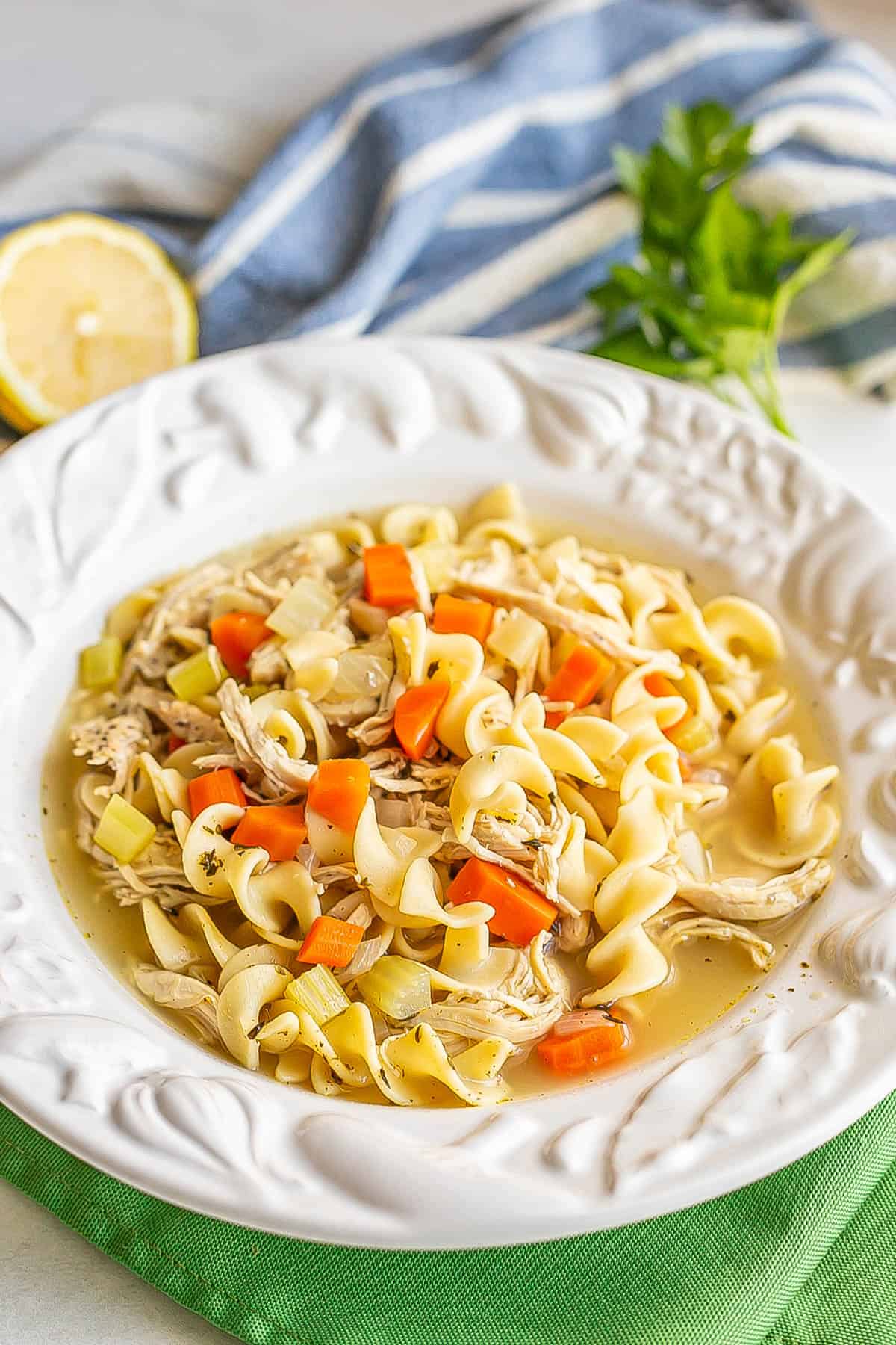 Chicken noodle soup served in a white rimmed soup bowl.