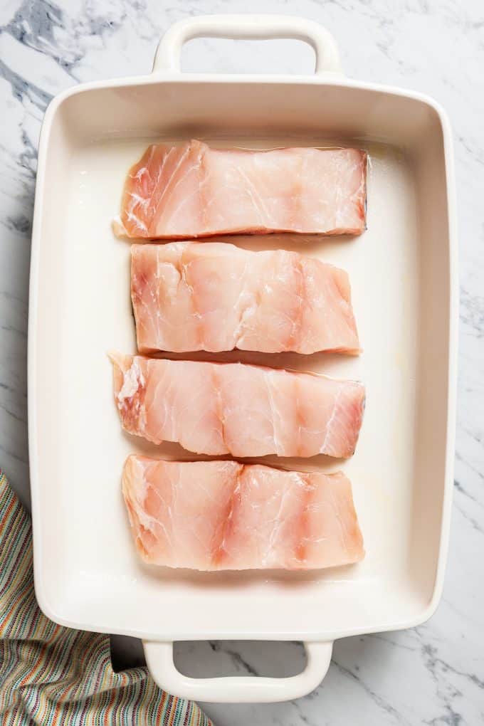 Four pieces of grouper filet placed in a large casserole dish.