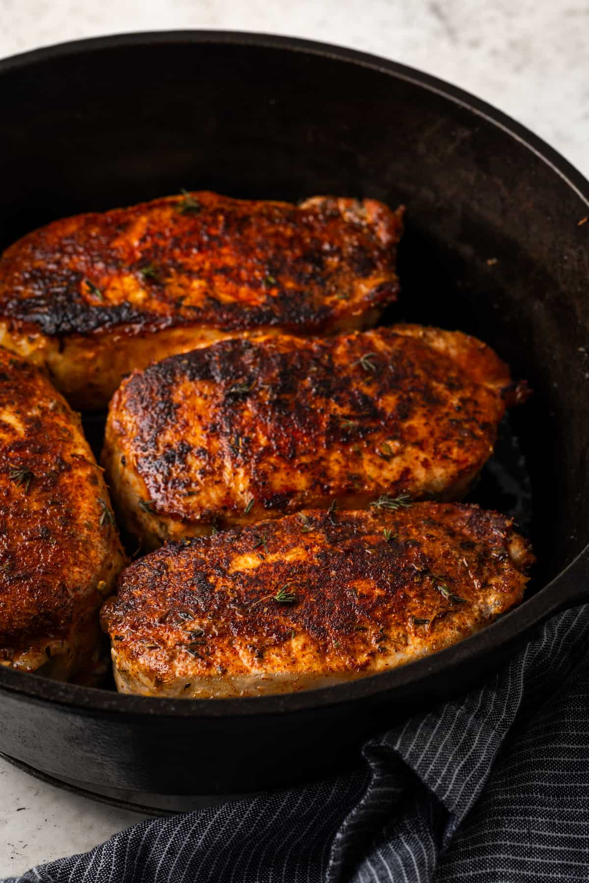 Boneless pork chops seared and cooked in a cast iron skillet.