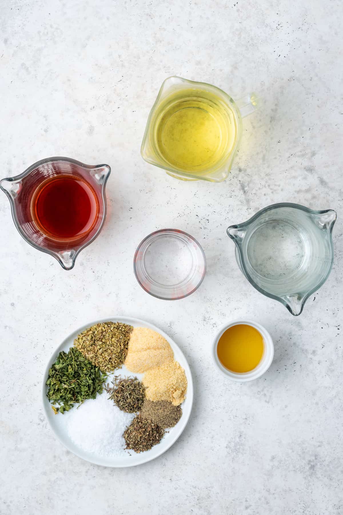 Ingredients laid out on a counter to make homemade Italian salad dressing.