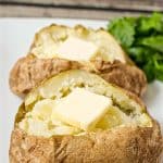 Two microwave baked potatoes on a white platter with pats of butter in each one and a text overlay on the photo.