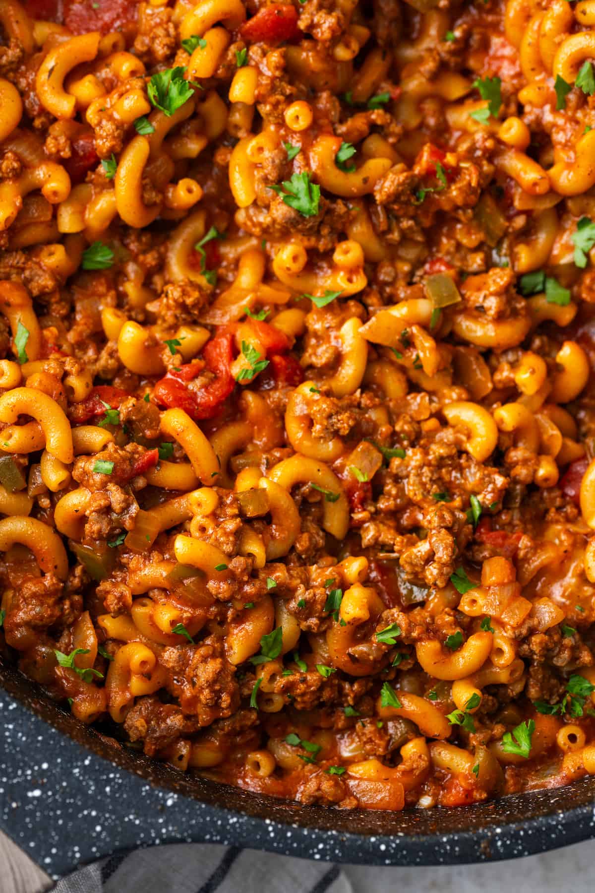 Close up of one pan goulash in a skillet with chopped fresh parsley sprinkled on top.