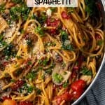 Vegetarian spaghetti with mushrooms, spinach and tomatoes all cooked in a large skillet with a text overlay on the photo.