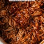 Close up of pulled pork with BBQ sauce in a slow cooker insert with a text overlay on the photo.