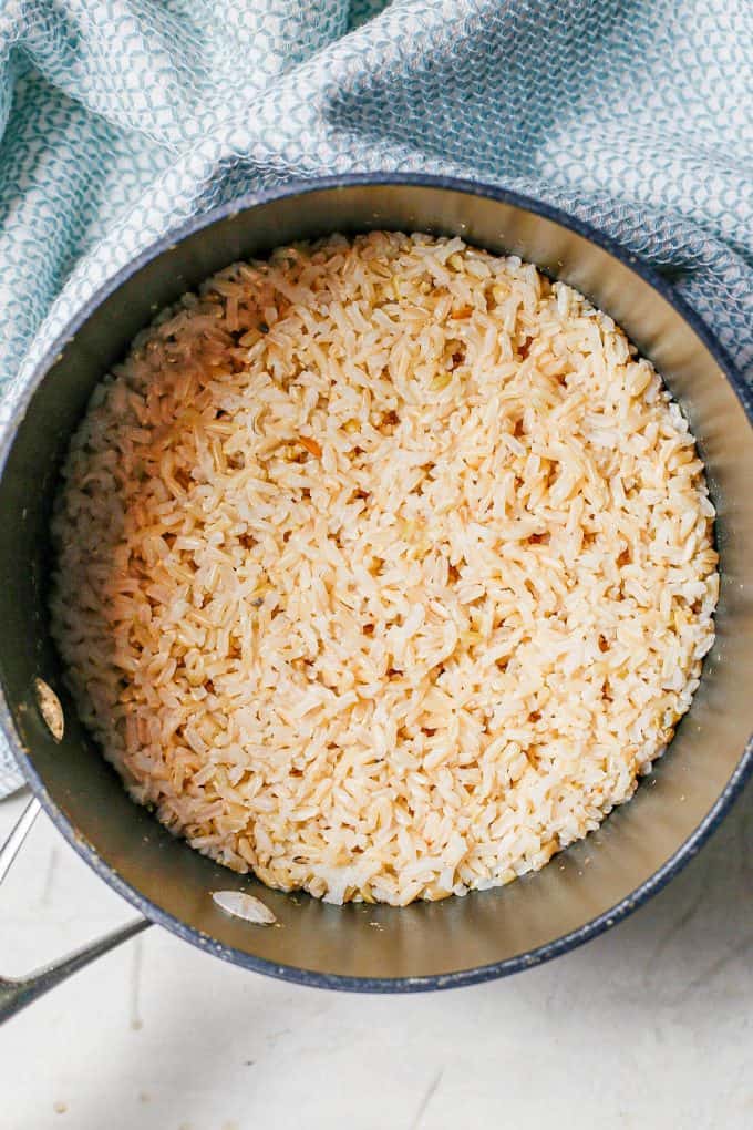 Brown rice in a dark pan just after finishing cooking.