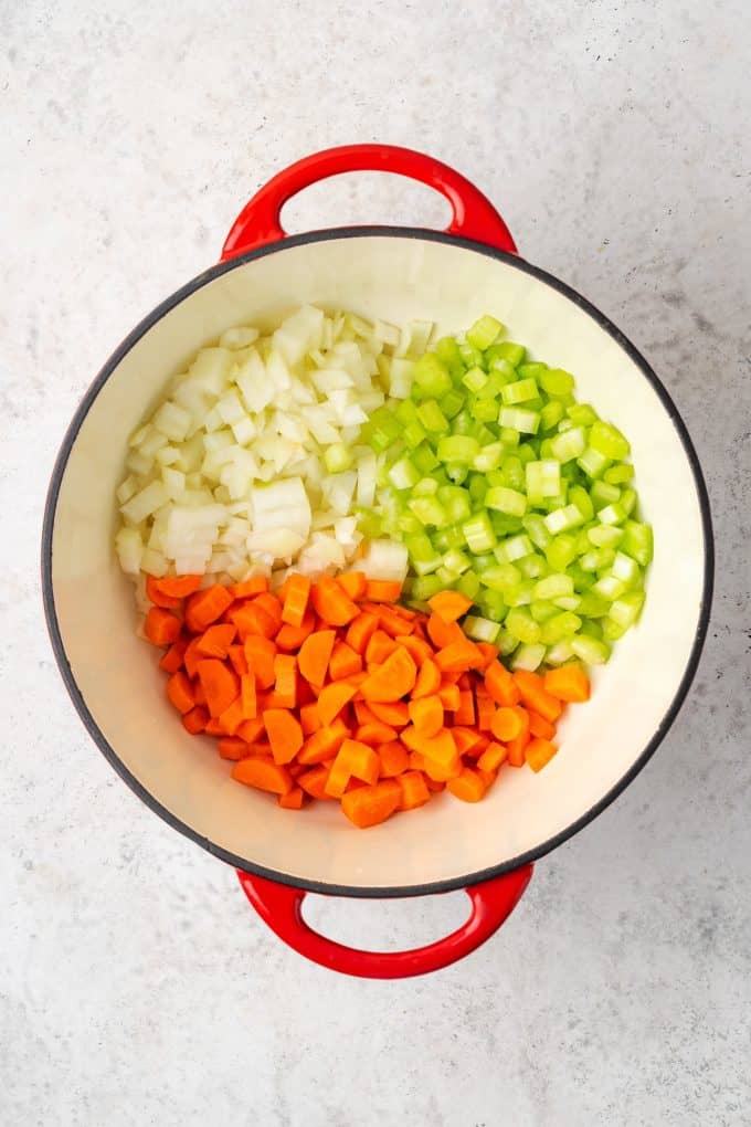 Chopped onions, celery and carrots in a large pot before being sautéed.