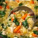 A silver ladle scooping up lemony chicken orzo soup with spinach from a large pot with a text overlay on the photo.