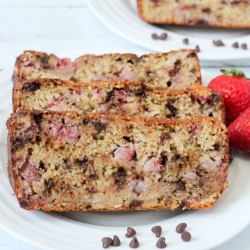 Close up of slices of strawberry oat bread with mini chocolate chips on a white plate.