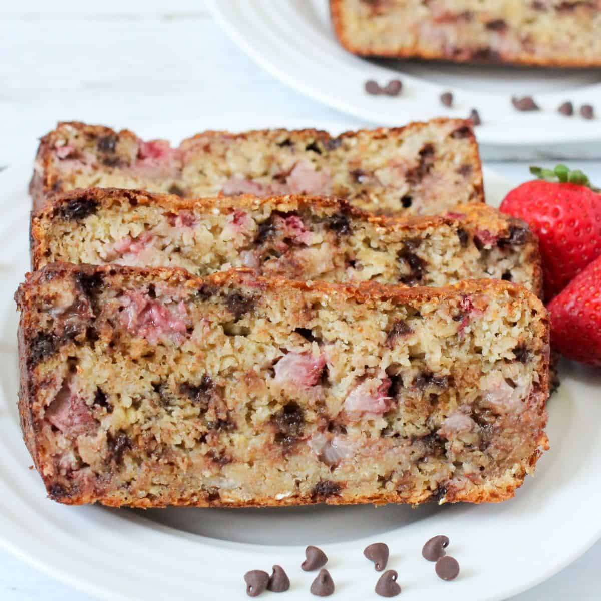 Close up of slices of strawberry oat bread with mini chocolate chips on a white plate.