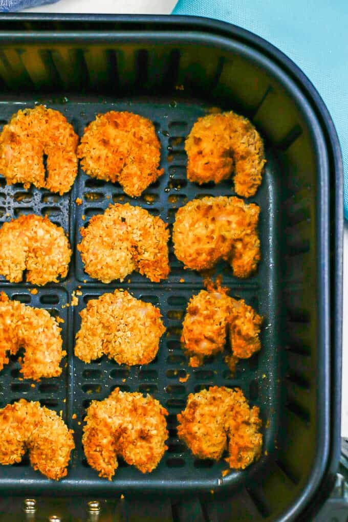 Close up of crispy cooked breaded shrimp in an Air Fryer insert.