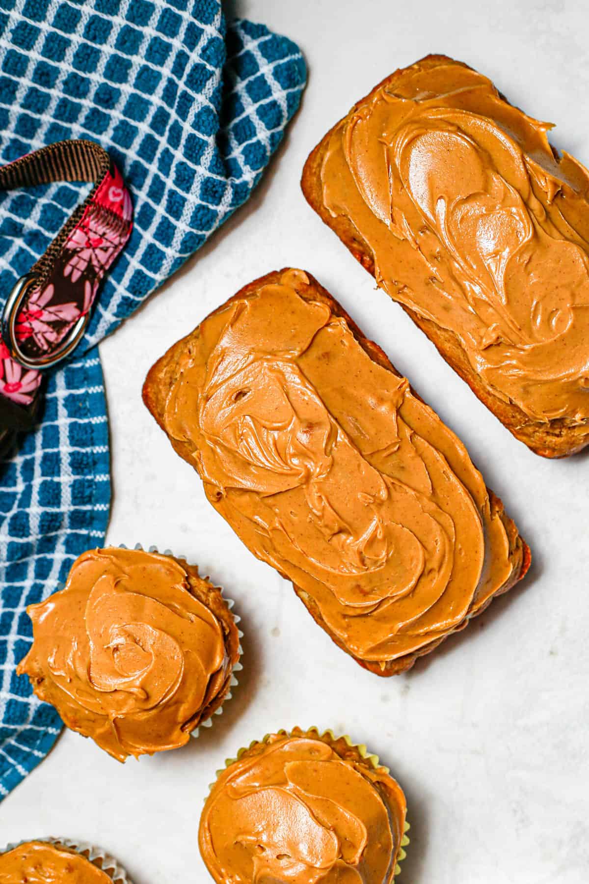 Close up of mini dog cakes in a small loaf form with peanut butter on top as frosting.