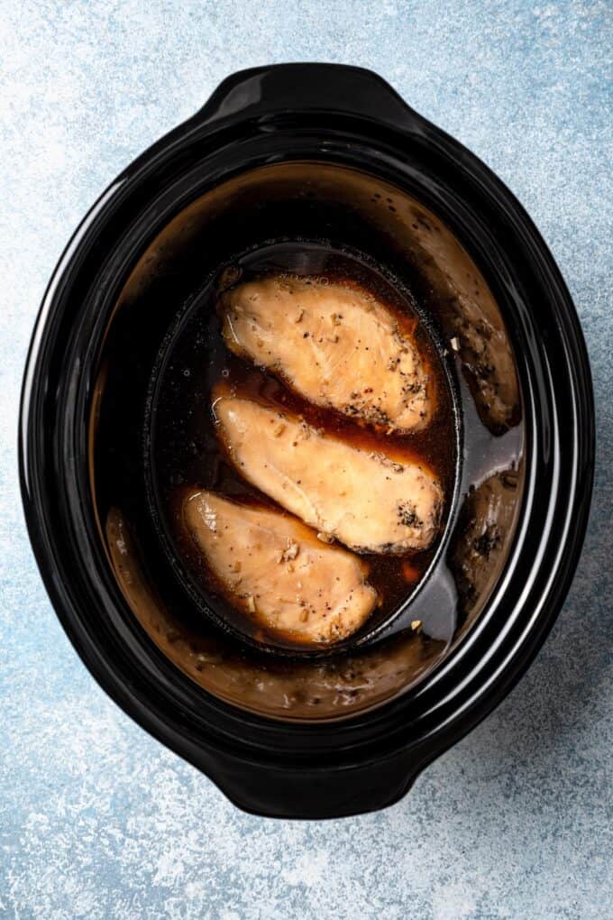 Cooked bourbon chicken in a crock pot insert.