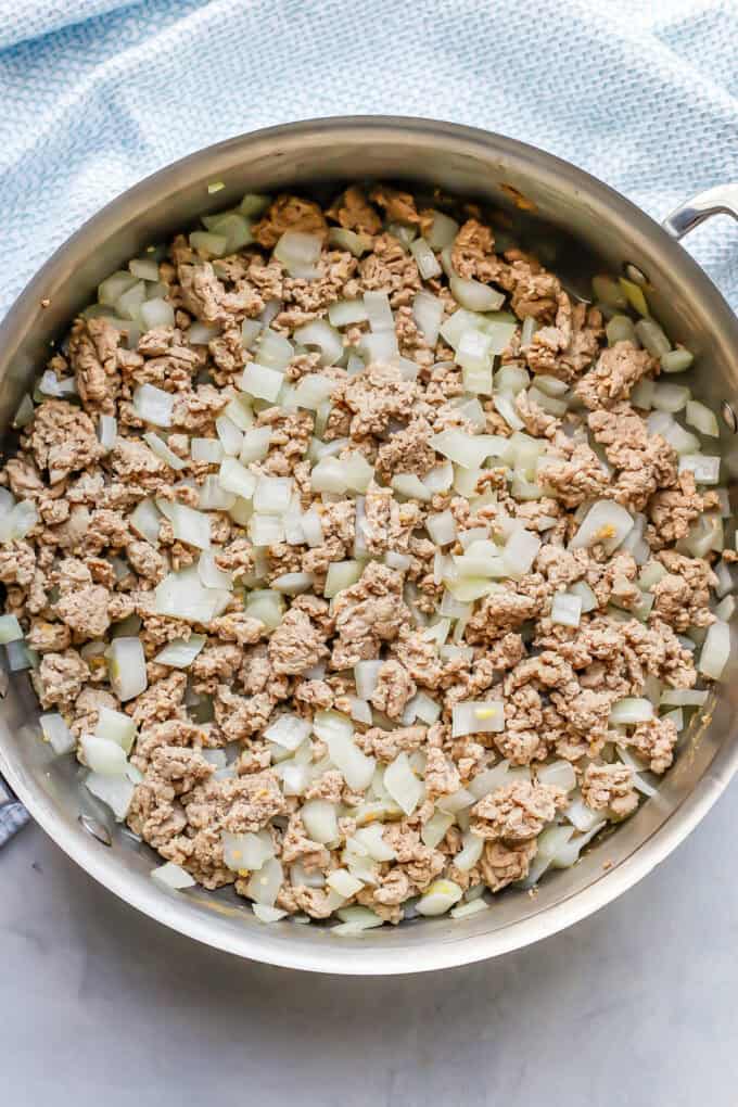 Ground turkey and onion cooked together in a large deep skillet.